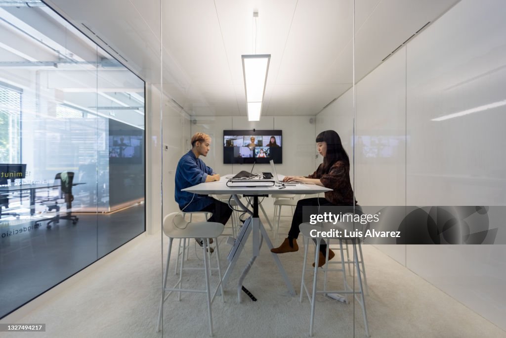 Man and woman working in hybrid office cubicle