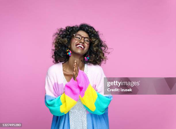 excited woman wearing rainbow cardigan - accessoire de spectacle stockfoto's en -beelden