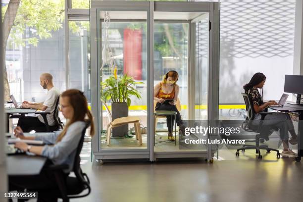 people working in hybrid office space - oficina de plan abierto fotografías e imágenes de stock