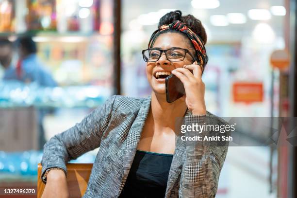 glückliches mädchen, das telefoniert, während es im café sitzt. - student girl using laptop computer and smart phone stock-fotos und bilder
