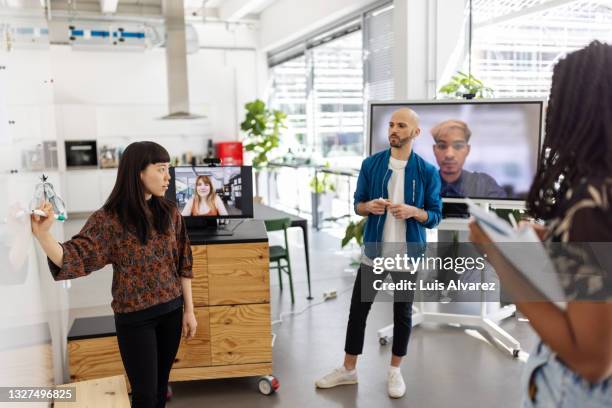 businesswoman giving presentation to team on whiteboard - employee engagement remote stock pictures, royalty-free photos & images