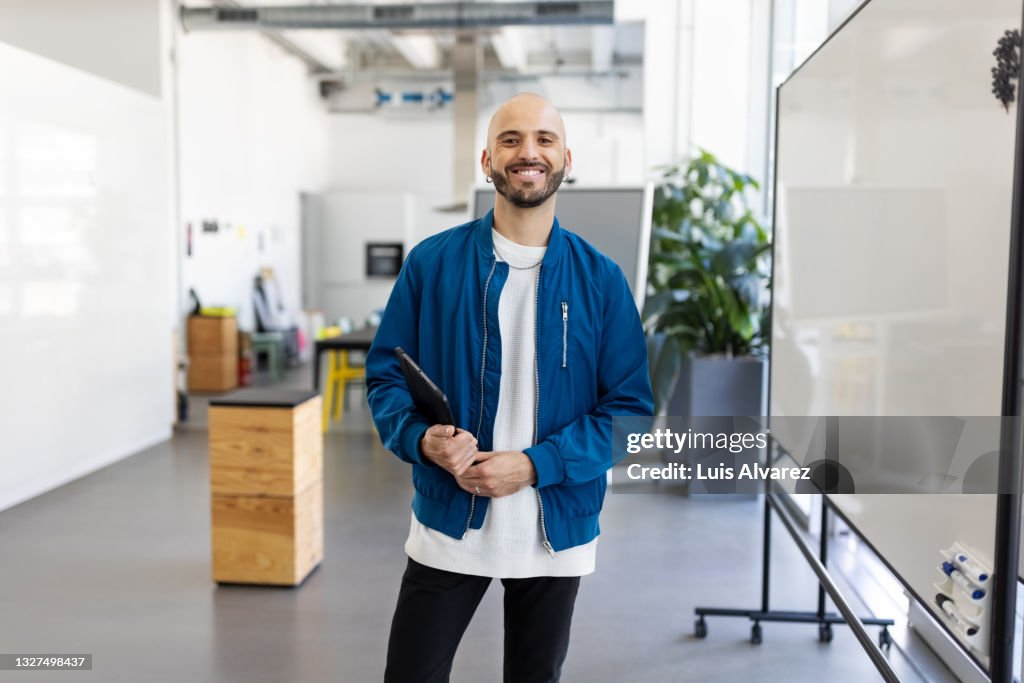 Portrait of a bald businessman holding digital tablet