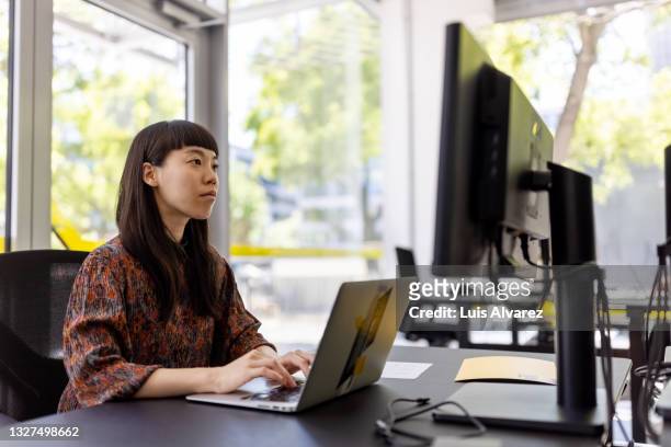 businesswoman working at her office desk - web designer fotografías e imágenes de stock