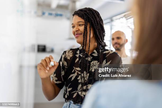 woman sharing her ideas with team in meeting - diversity workplace stock pictures, royalty-free photos & images