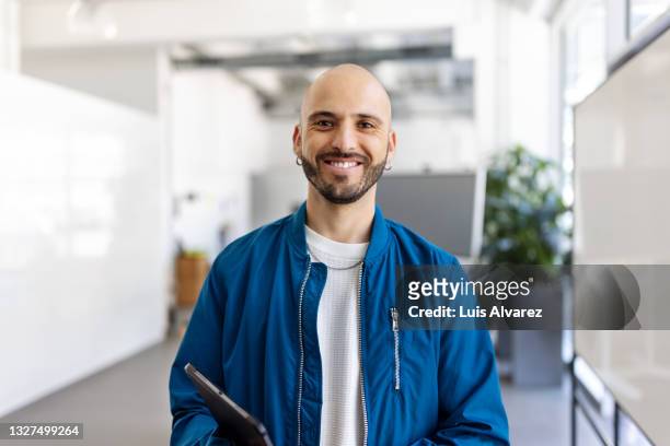 portrait of a bald headed man in startup office - bald 30s stockfoto's en -beelden