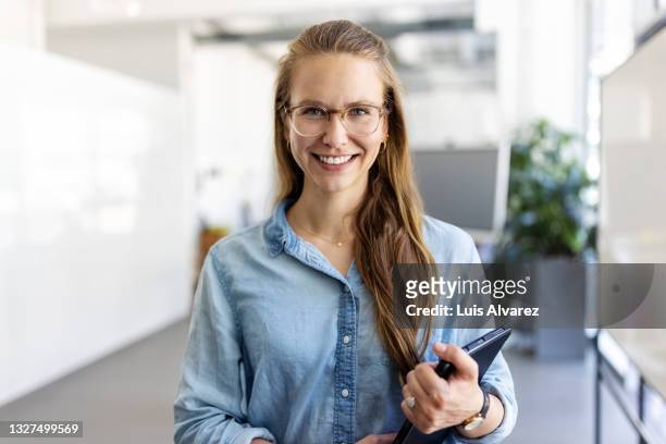 portrait of a confident young businesswoman - employee satisfaction stock pictures, royalty-free photos & images