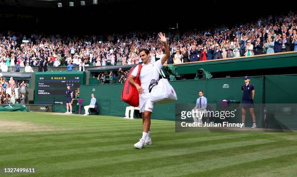 Roger Federer of Switzerland waves to the crowd after losing his men's Singles Quarter Final match against Hubert Hurkacz of Poland on Day Nine of...