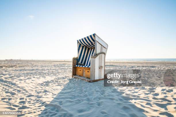 hooded beach chair on nordstrand beach (sunset) - east frisian islands stock pictures, royalty-free photos & images