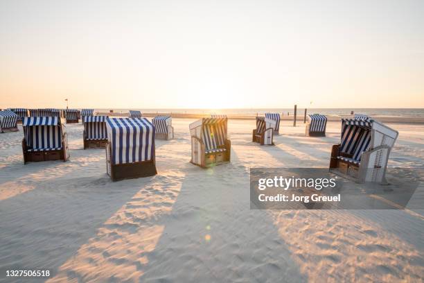 hooded beach chairs on nordstrand beach (sunset) - east frisian islands stock pictures, royalty-free photos & images