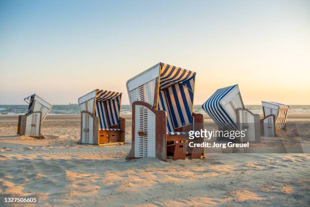 hooded beach chairs on nordstrand beach (sunrise) - norderney photos et images de collection
