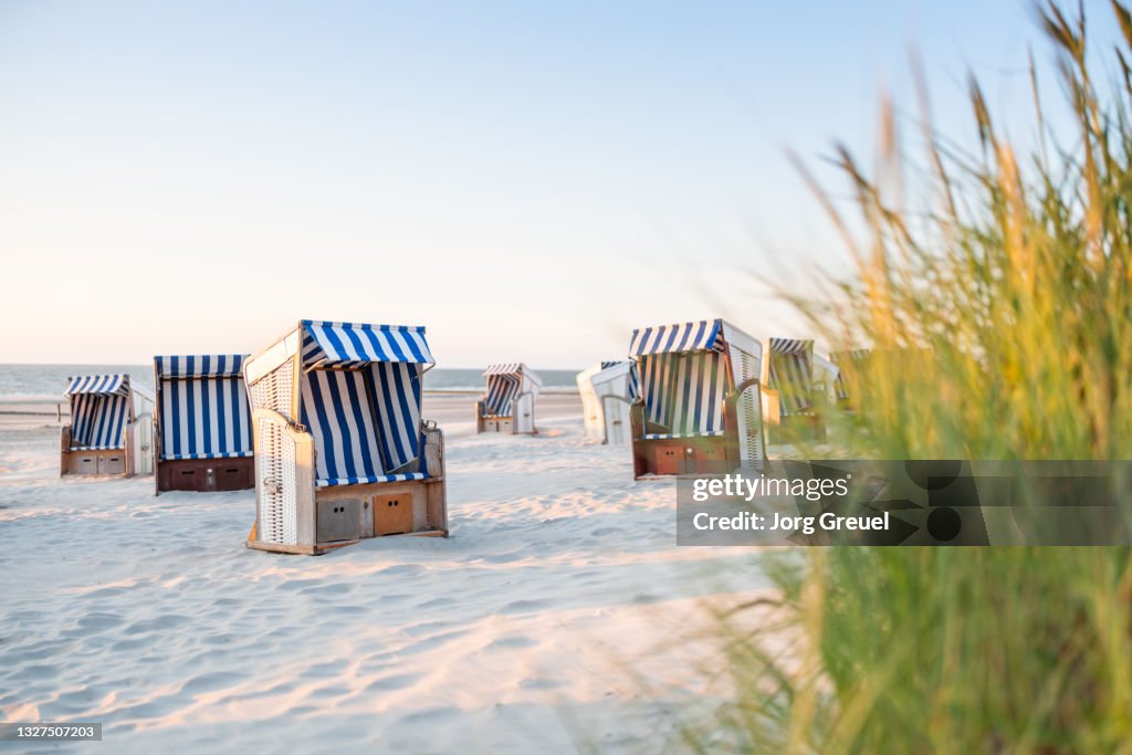 Hooded beach chairs on Nordstrand beach (sunset)