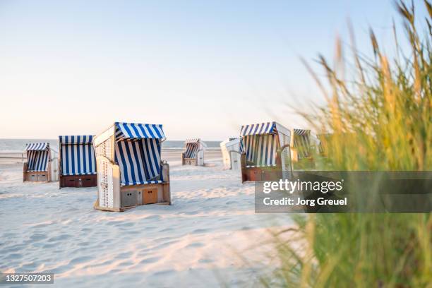hooded beach chairs on nordstrand beach (sunset) - norderney photos et images de collection