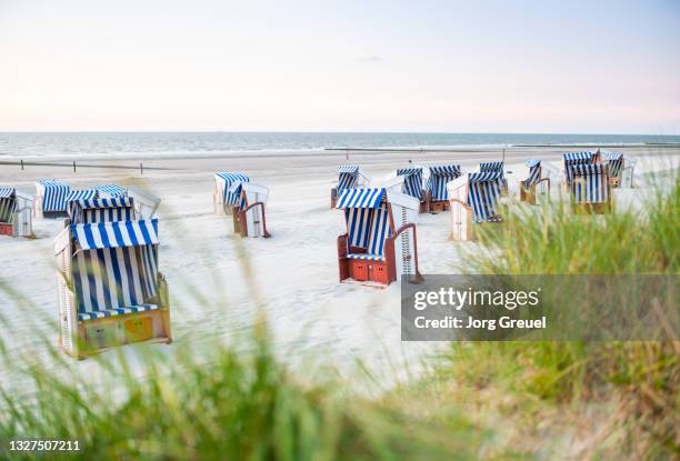 hooded beach chairs on nordstrand beach (dusk) - norderney photos et images de collection