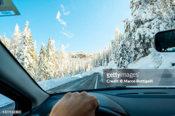 personal perspective of person driving car in snow, dolomites, italy - förarsäte bildbanksfoton och bilder