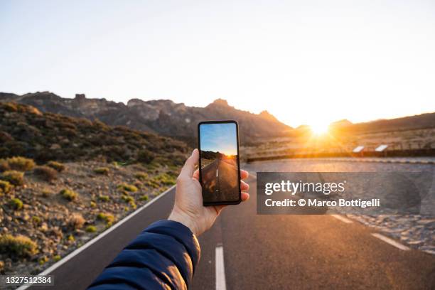 personal perspective of person photographing empty road at sunset, tenerife, spain - beauty photo shoot stock pictures, royalty-free photos & images