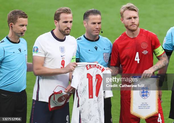 Assistant Referee, Jan de Vries, Harry Kane of England, Match Referee, Danny Makkelie and Simon Kjaer of Denmark hold a signed England shirt of...