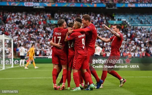 Mikkel Damsgaard of Denmark celebrates with teammates after scoring their team's first goal during the UEFA Euro 2020 Championship Semi-final match...