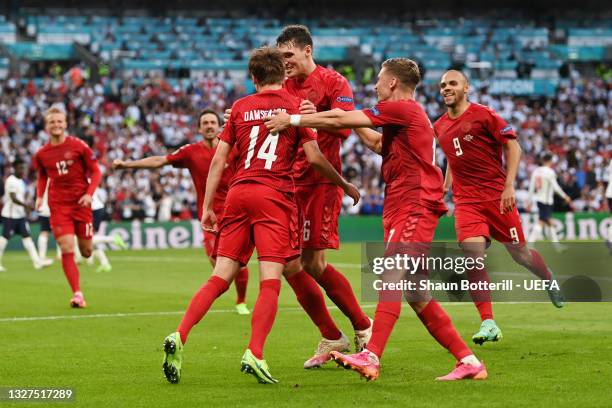 Mikkel Damsgaard of Denmark celebrates with teammates Andreas Christensen and Jens Stryger Larsen after scoring their team's first goal during the...