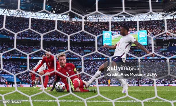 Simon Kjaer of Denmark scores an own goal for the England first goal whilst under pressure from Raheem Sterling of England during the UEFA Euro 2020...