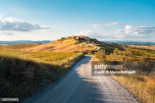 country road to hilltop village, tuscany, italy - 托斯卡尼 個照片及圖片檔