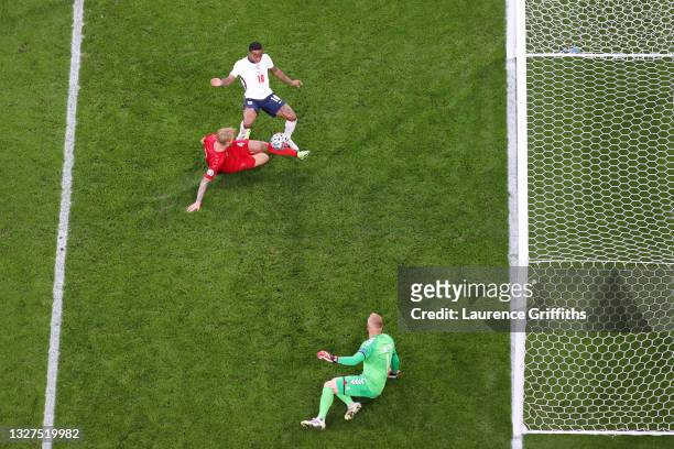 Simon Kjaer of Denmark scores an own goal, England's first goal whilst under pressure from Raheem Sterling of England during the UEFA Euro 2020...