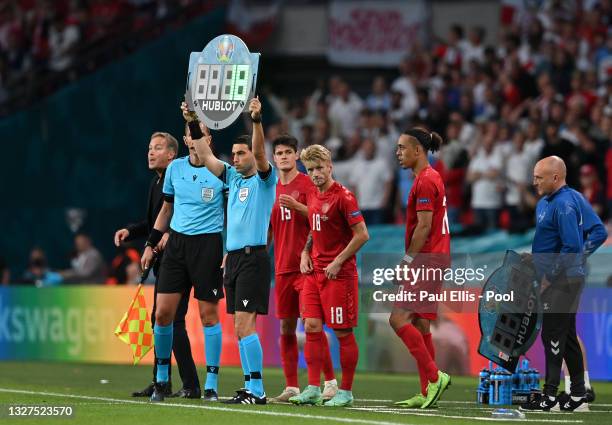 Fourth Official, Ovidiu Hategan holds aloft the substitutes board as Christian Norgaard, Daniel Wass and Yussuf Poulsen of Denmark prepare to come on...