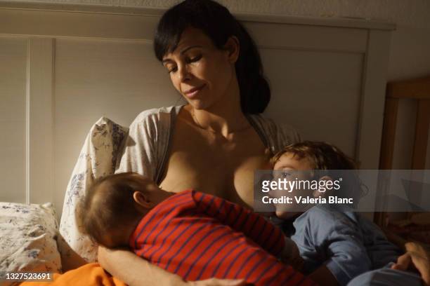 彼女の子供を母乳で育てる女性 - jet lag ストックフォトと画像
