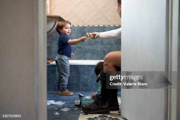 mother with her children in the bathroom - baby pee stockfoto's en -beelden