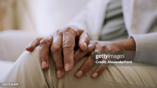 of a senior woman's hands while sitting at home - weduwe stockfoto's en -beelden