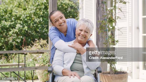shot of a senior woman sitting in her wheelchair while spending time outdoors with her nurse - nurse recruitment stock pictures, royalty-free photos & images