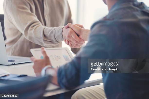 close up of businessmen shaking hands. - ipad close up imagens e fotografias de stock