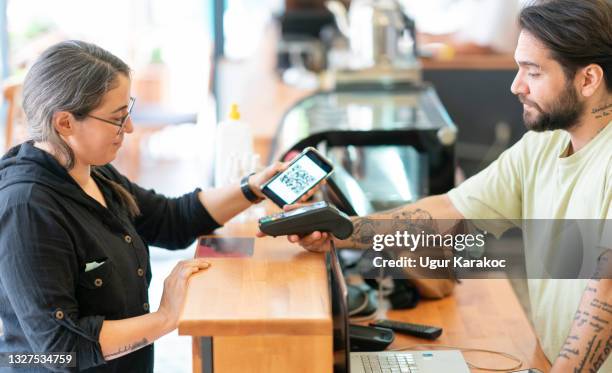 young woman paying with smartphone - bar code imagens e fotografias de stock