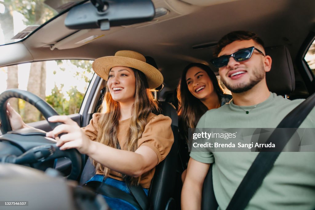 Happy friends traveling by car