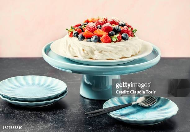 pavlova desert on black background - dessert topping stock pictures, royalty-free photos & images