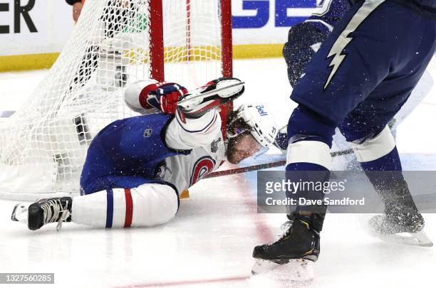Josh Anderson of the Montreal Canadiens falls to the ice and hits the post after taking a shot on goaltender Andrei Vasilevskiy of the Tampa Bay...