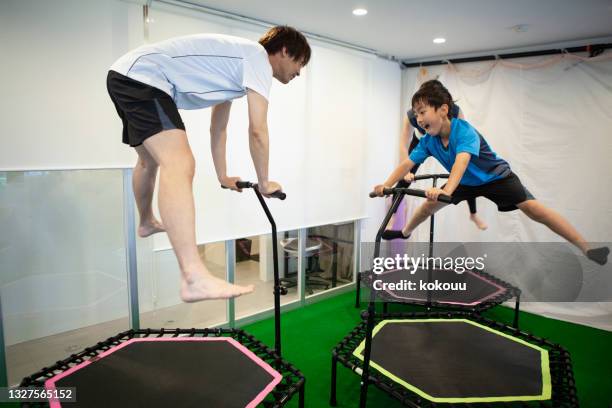 family training on a trampoline at the gym. - trampoline jump stock pictures, royalty-free photos & images