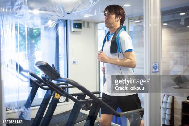 トレーニングジムでトレッドミルを使用しているアスリートの男性。 - fitness club ストックフォトと画像