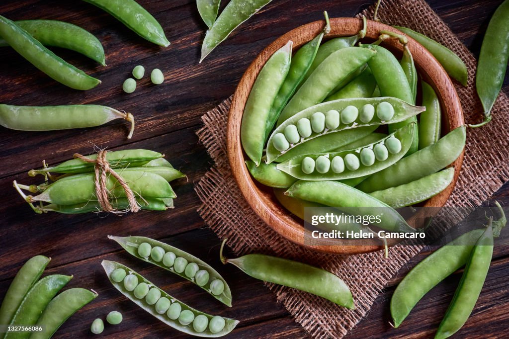 Fresh green peas on rustic wooden table