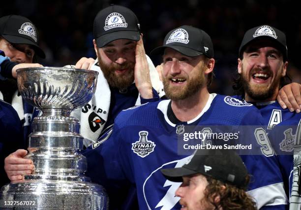 Captain Steven Stamkos of the Tampa Bay Lightning smiles with teammates Pat Maroon, Victor Hedman and Ryan McDonagh with Stamkos' arm around the...