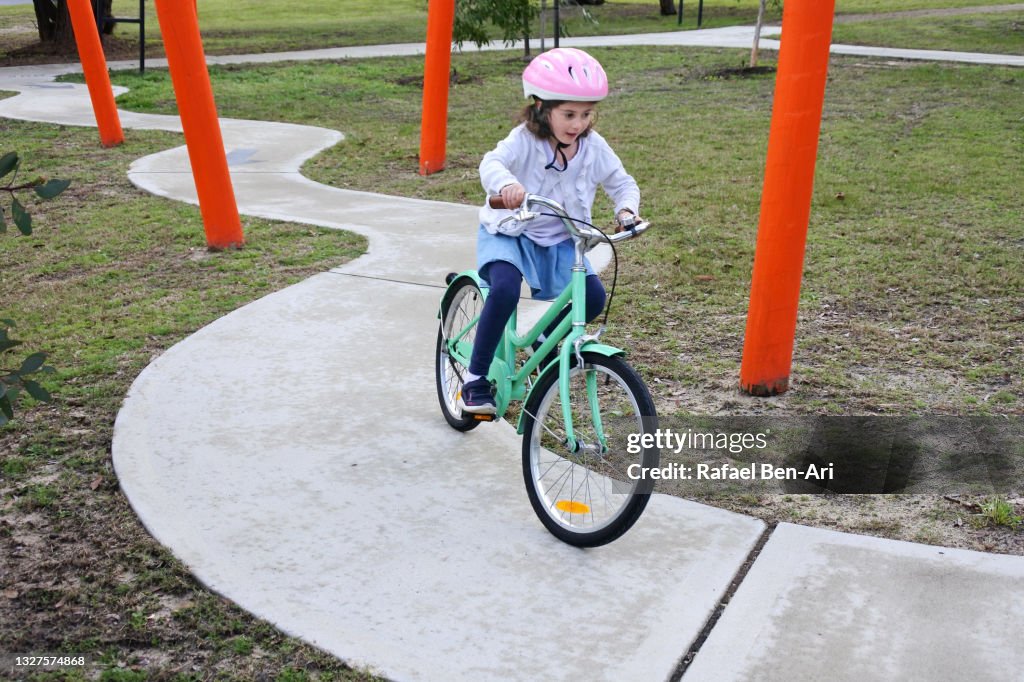 Young girlriding on bicycle on a bike path