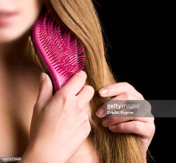 female hand holding hair brush - cepillar el cabello fotografías e imágenes de stock