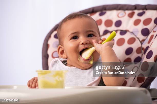 adorable bébé mangeant de la nourriture par lui-même. - puree photos et images de collection