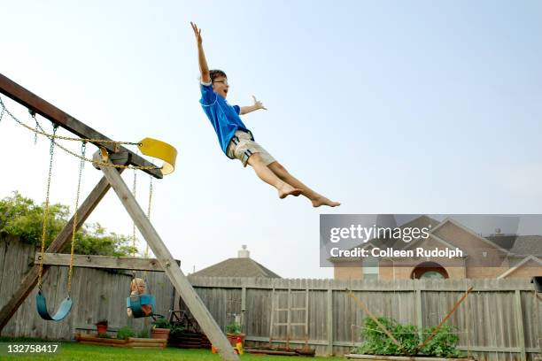 boy jumps off swing in his backyard - rudolph stock pictures, royalty-free photos & images