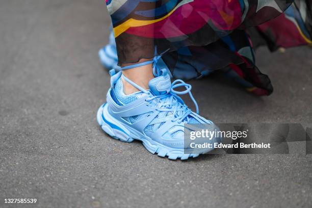 Gabriella Berdugo wears a black transparent / tulle multicolored print pattern ruffled long dress, blue leather sneakers from Balenciaga, outside...