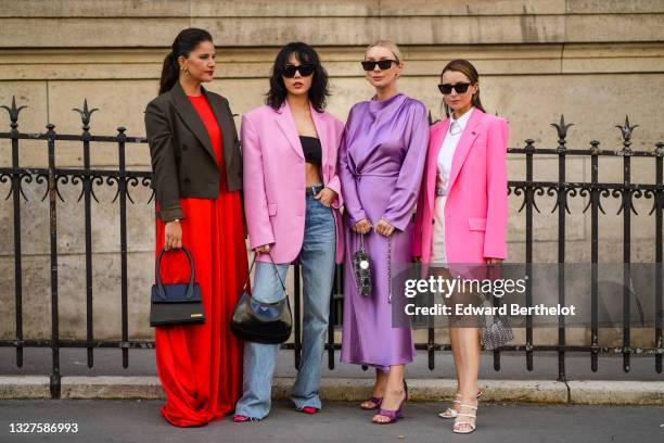 Gili Biegun wears gold Fendi earrings, gold earrings, a red long flowing dress, gray short blazer jacket, a black shiny leather Chiquito handbag from...