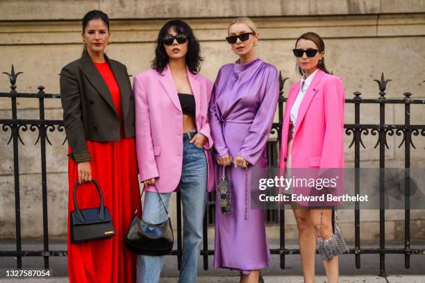 Gili Biegun wears gold Fendi earrings, gold earrings, a red long flowing dress, gray short blazer jacket, a black shiny leather Chiquito handbag from...