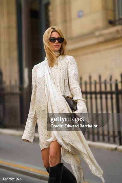 Natalia Verza wears a Fendi total look composed of black sunglasses, a white with black polka dots turtleneck / long sleeves / ruffled asymmetric...