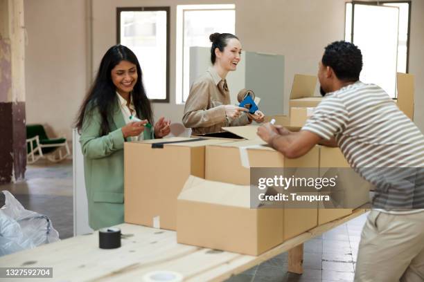 business people packing and unpacking in a new office. - moving office stock pictures, royalty-free photos & images