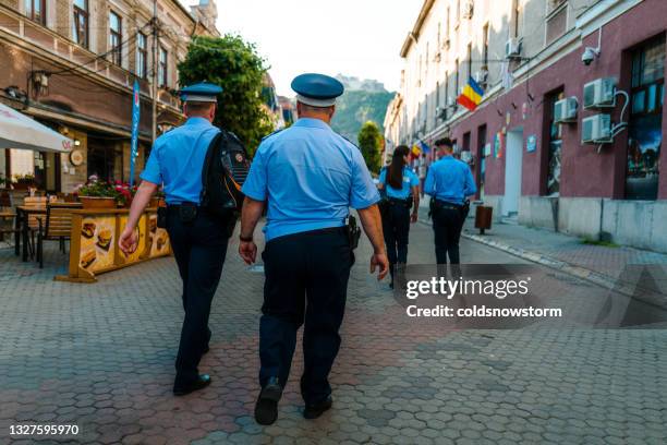 romanian police officers walking on city street - police romania stock pictures, royalty-free photos & images