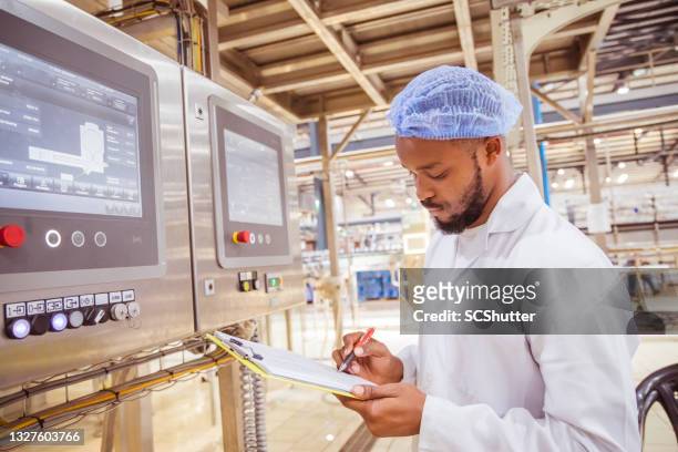 lavoratori della fabbrica africana / zambiana che monitorano il pannello elettrico nella fabbrica di bevande - medical device foto e immagini stock